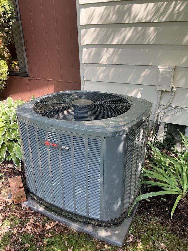 Completed MVP cooling maintenance visit on 10-year-old Trane air conditioning system. Performed comprehensive inspection of outdoor condenser unit and indoor furnace components, verified proper operation of all equipment, checked refrigerant lines and electrical connections, and documented system condition with photos showing unit positioned on concrete pad with appropriate clearances and indoor equipment properly installed with gas lines and PVC venting in place.