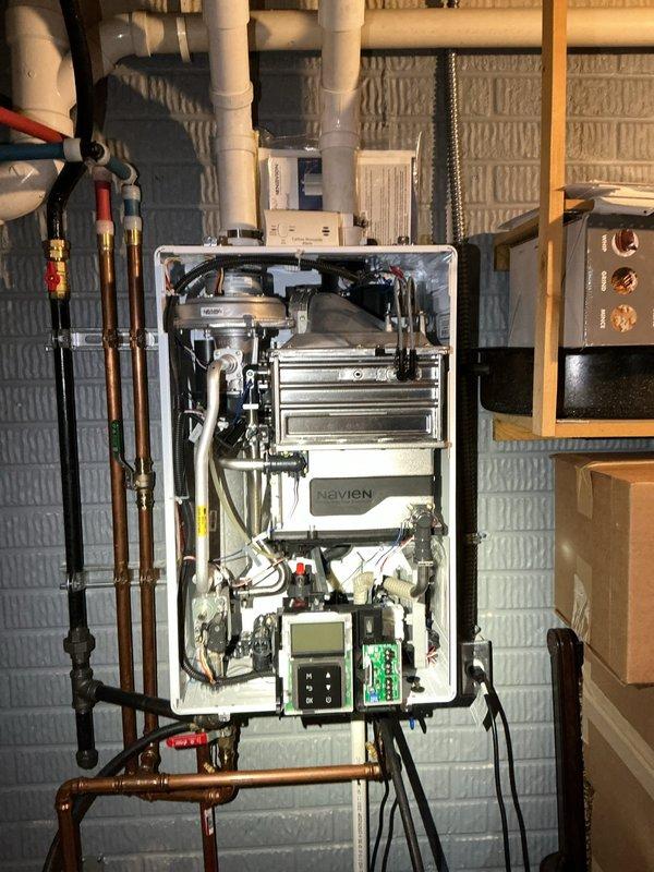 Completed preventive maintenance descaling and flush service on Navien tankless water heater unit. Performed full system descale using circulation pump and descaling solution through isolation valves, flushing heat exchanger to remove mineral buildup and maintain optimal efficiency. Verified unit operation, checked all connections, and confirmed proper function of control panel and display upon completion.