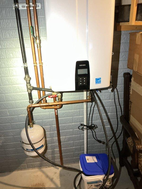 Completed preventive maintenance descaling and flush service on Navien tankless water heater unit. Performed full system descale using circulation pump and descaling solution through isolation valves, flushing heat exchanger to remove mineral buildup and maintain optimal efficiency. Verified unit operation, checked all connections, and confirmed proper function of control panel and display upon completion.