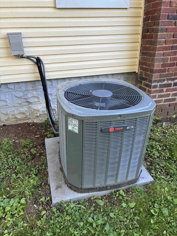 Performed routine maintenance visit on 12-year-old Trane condensing unit. Inspected electrical components including capacitor, wiring connections, and control circuitry within cabinet. All wire connections secure with proper terminations noted. Capacitor showing normal operation with blue wire connectors properly attached to terminals. Unit operational and running as designed.