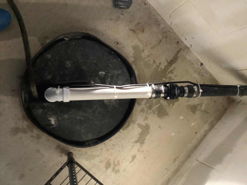 Responded to service call for sump pump replacement in 26-year-old residential property. Upon arrival, assessed existing sump pump system and surrounding basement conditions, noting moisture staining and discoloration on concrete surfaces around the pit area indicating long-term water exposure. Removed old sump pump unit and prepared sump pit for new installation. Installed replacement sump pump with new pit cover assembly and configured discharge piping system using PVC materials. Verified proper pipe connections, fittings, and secure mounting of all components. Tested pump operation to ensure proper functionality and adequate drainage capability. Secured all electrical connections and discharge lines. Left work area clean with new system fully operational and ready for service.