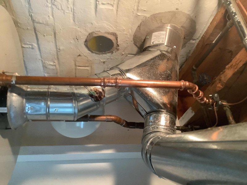 Responded to a recurring water leak from a fitting located directly above the hot water tank. Upon inspection, identified a leaking copper pipe connection at a soldered joint that was causing water to drip onto the top of the water heater. Repaired the defective fitting by re-soldering the connection to ensure a proper watertight seal. Verified all surrounding copper piping and connections in the mechanical space for additional leaks or potential issues. Tested the repaired fitting under pressure to confirm the leak was resolved and no further dripping occurred.