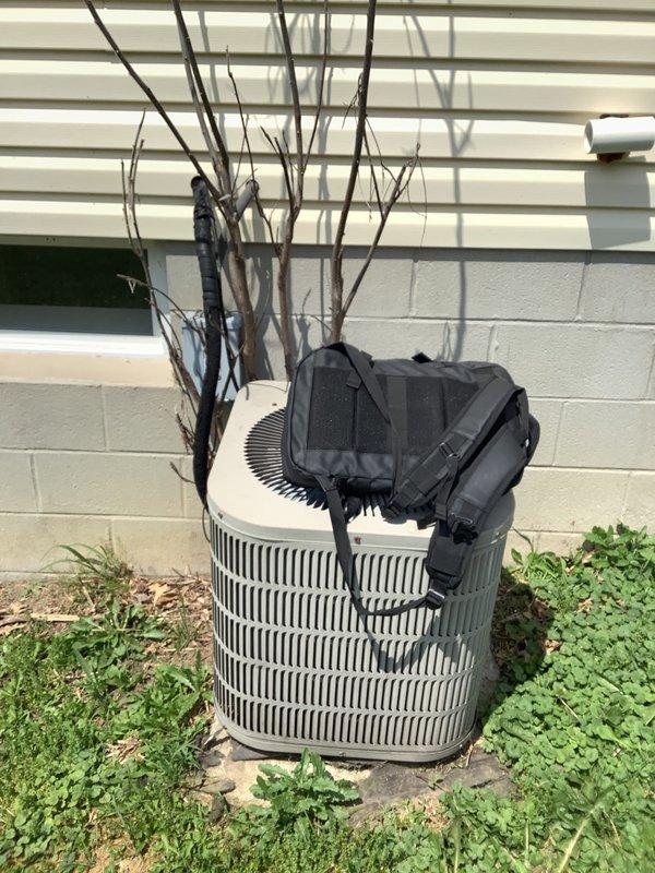 Conducted on-site evaluation of 22-year-old air conditioning system for replacement estimate. Inspected outdoor condenser unit and assessed A-coil replacement requirements. Unit showed signs of age-appropriate wear, with vegetation debris accumulation on top of condenser and overgrown plant material in immediate vicinity affecting proper airflow and maintenance access. Photographed existing equipment configuration, electrical disconnect box, and refrigerant line routing for replacement planning. Documented current system specifications and site conditions to provide accurate equipment sizing and installation scope for complete HVAC system replacement.