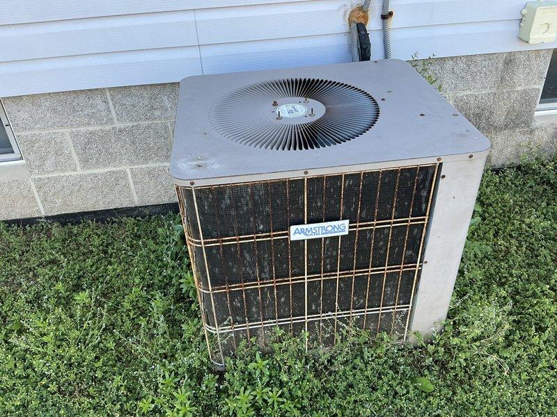 Conducted comprehensive HVAC system evaluation for complete replacement estimate. Assessed existing Armstrong Air furnace/air handler unit installed on residential garage floor and outdoor Armstrong condenser unit positioned on concrete pad adjacent to building foundation. Documented current equipment condition, specifications, and installation configuration including ductwork connections, refrigerant line routing, and electrical service. Evaluated both indoor and outdoor unit performance, noted aging equipment with visible weathering and potential maintenance concerns on outdoor condenser coils. Provided detailed photographic documentation of existing system components and installation environment to support replacement recommendations and equipment sizing requirements.