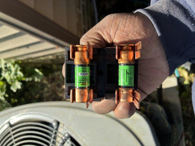 Completed scheduled maintenance visit on residential cooling system. Performed diagnostic testing using digital multimeter, recording voltage reading of 7.59 volts at control circuit. Inspected and replaced dual electrical fuses in disconnect box due to wear and discoloration on copper end caps. Verified all electrical connections, tested capacitor functionality, and confirmed proper system operation upon completion.