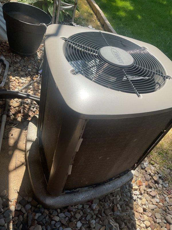 Completed preventive maintenance cooling visit on 8-year-old residential air conditioning system. Inspected outdoor condenser unit, verified proper operation of fan assembly and protective guard, confirmed unit is level on concrete pad with adequate gravel drainage, and measured system performance parameters registering 45 degrees, indicating normal cooling operation.
