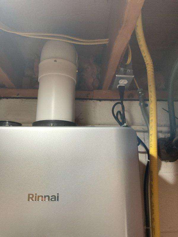 Removed existing RL75 tankless water heater and replaced with new Rinnai RU199iN tankless water heater unit. Installation included integration of condensation pump with associated tubing and complete tankless installation kit. Configured white PVC venting system routed through ceiling structure and established proper electrical connections at junction box. Verified all water supply connections, tested unit operation, and confirmed proper condensate drainage through pump system.