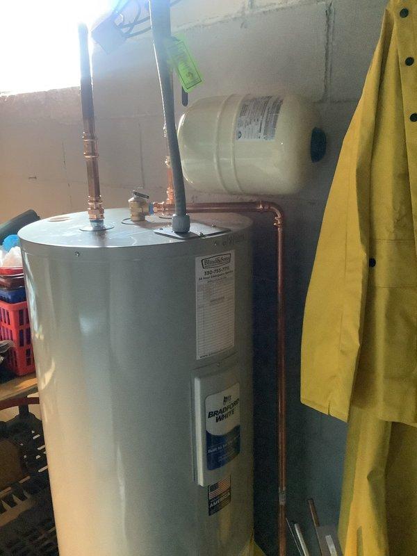 Removed existing water heater and installed new Bradford White 50-gallon electric water heater in basement utility area. Brought installation up to current code requirements by properly bonding the unit and installing a thermal expansion tank with copper piping connections. Verified existing shut-off valve was in working condition and incorporated into new installation. Registered the new unit with manufacturer upon completion.

Performed toilet flange replacement by cutting out deteriorated section of cast iron drain line in basement and installing new PVC piping with proper tie-in points to existing drainage system. Secured new toilet flange to repaired subfloor, preparing area for future toilet installation. All plumbing connections tested and verified for proper operation and code compliance.
