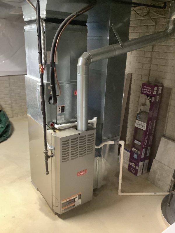 Completed installation of 80% efficiency furnace and air conditioning system in residential basement utility area. New furnace unit installed with proper venting and ductwork connections, including rectangular supply plenum and horizontal distribution runs. AC system integrated with furnace for complete HVAC solution, ensuring proper refrigerant lines and condensate drainage. All equipment secured per manufacturer specifications, electrical connections completed, and system tested for proper operation and airflow distribution throughout the home.