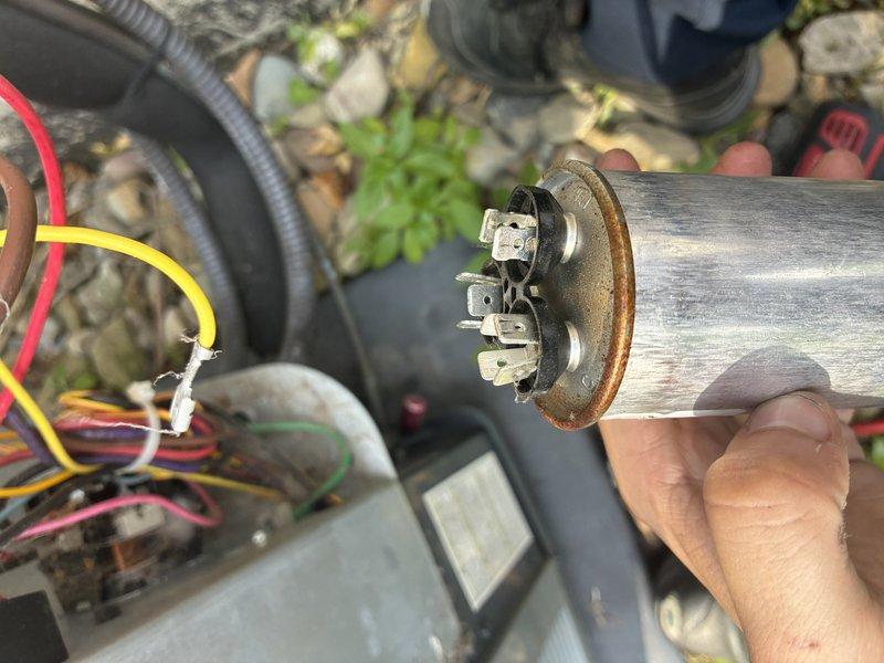 Responded to no cooling complaint. Upon arrival, found outdoor condensing unit not operating. Inspection revealed failed dual run capacitor with visible corrosion on terminals and mounting bracket. Removed defective capacitor, cleaned electrical connections, and installed new dual run capacitor. Verified proper voltage and amperage readings. Tested system operation and confirmed unit cooling properly with adequate airflow and temperature differential across evaporator coil.