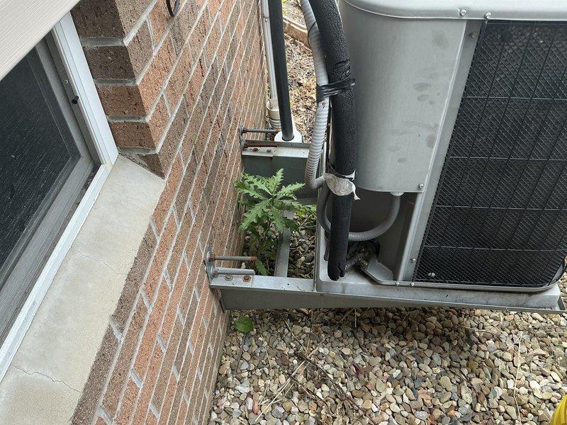 Provided estimate for replacement of 19-year-old residential air conditioning system. Existing outdoor condenser unit currently positioned on concrete pad against brick exterior with refrigerant lines running along building wall. Quoted complete system replacement including new condenser unit, installation, and necessary line work.