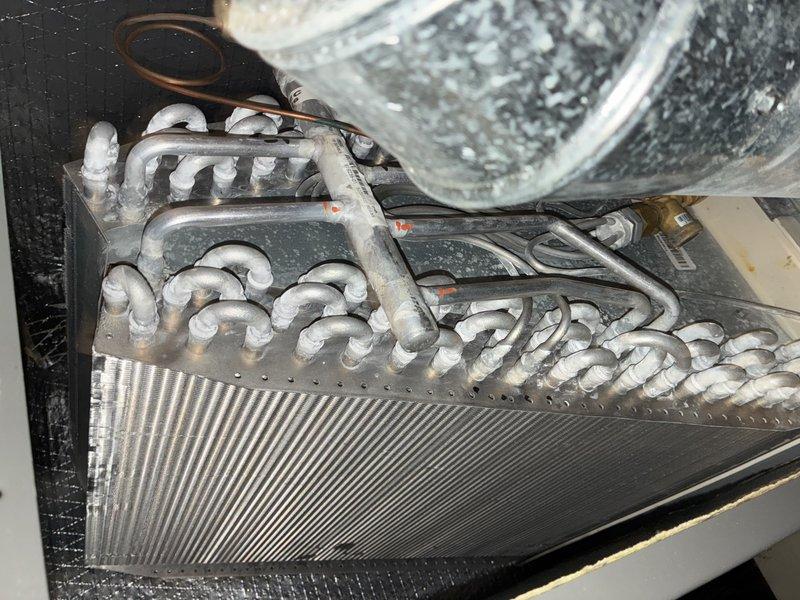Performed routine MVP cooling maintenance visit on 3-year-old air conditioning system. Upon inspection, discovered extensive frost and ice buildup on evaporator coil assembly, copper refrigerant lines, and heat exchanger fins, indicating abnormal operating condition. Documented frozen coil condition and electrical control panel components with photos. Frost accumulation on copper tubing and finned heat exchanger suggests potential airflow restriction, refrigerant charge issue, or system cycling problem requiring further diagnosis and corrective action.