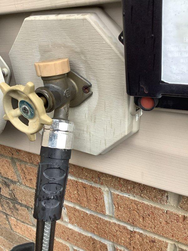 Replaced defective outdoor water spigot with new frost-free hose bib assembly. The existing valve showed significant wear and corrosion, requiring complete replacement to restore proper function and prevent potential leaks. Installation included securing the new fixture to the exterior wall where vinyl siding meets brick masonry, ensuring proper water flow and operational integrity for outdoor water access.