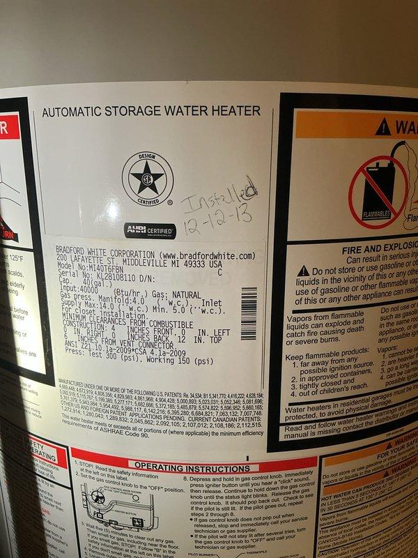 Responded to service call for leaking 19-year-old Bradford White automatic storage water heater. Upon inspection, confirmed active leak from aging unit installed in 2018. Documented condition of water heater including manufacturer specifications, safety labels, and surrounding copper supply piping with visible oxidation. Given the age and condition of the unit, recommended replacement to prevent further water damage and ensure reliable hot water service.