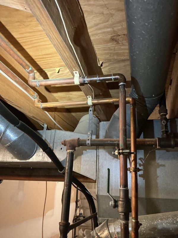 Responded to service call for leaking 19-year-old Bradford White automatic storage water heater. Upon inspection, confirmed active leak from aging unit installed in 2018. Documented condition of water heater including manufacturer specifications, safety labels, and surrounding copper supply piping with visible oxidation. Given the age and condition of the unit, recommended replacement to prevent further water damage and ensure reliable hot water service.