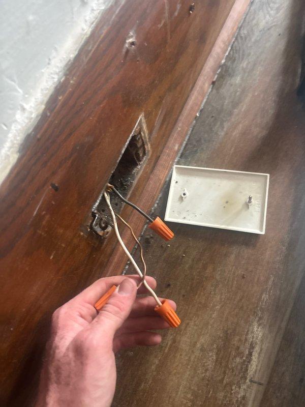 Responded to service call for living room outlet repeatedly tripping circuit breaker. Inspected electrical panel and identified affected circuit breaker controlling the problematic outlet. Investigated outlet wiring connections and discovered loose or improperly secured wire connections with orange wire nuts in junction box beneath floor surface. Re-secured all wire connections, verified proper wire gauge and connections met code requirements, tested circuit breaker for proper operation, and confirmed outlet now functions correctly without tripping breaker.
