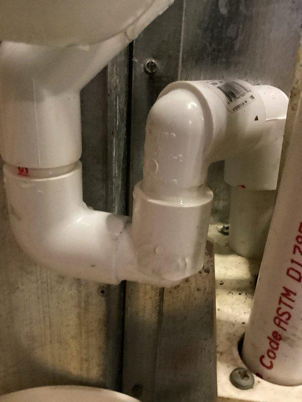 Responded to service call for reported leaking HVAC pipes on recently installed A/C system approximately one month post-installation. Upon arrival, inspected condensate drain line assembly and PVC piping configuration. Documented existing drain trap setup with photos showing white PVC components including U-trap, 90-degree elbows, and connection fittings meeting ASTM D-1785 standards. Advised customer that diagnostic visit may be subject to standard service call fee and obtained visual documentation of current plumbing configuration for assessment and future reference.