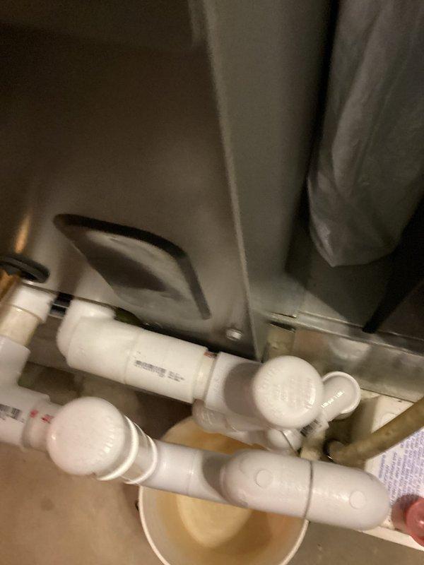 Responded to service call for reported leaking HVAC pipes on recently installed A/C system approximately one month post-installation. Upon arrival, inspected condensate drain line assembly and PVC piping configuration. Documented existing drain trap setup with photos showing white PVC components including U-trap, 90-degree elbows, and connection fittings meeting ASTM D-1785 standards. Advised customer that diagnostic visit may be subject to standard service call fee and obtained visual documentation of current plumbing configuration for assessment and future reference.