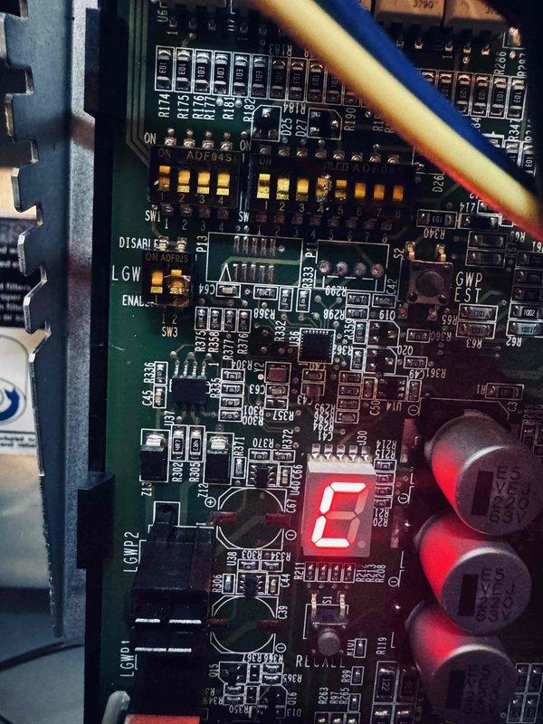 Responded to warranty service call for newly installed heat pump system with outdoor unit failing to power on since installation. Upon arrival, inspected outdoor heat exchanger and control board, discovering error code "E" displayed on circuit board LED indicator. Diagnosed control board failure preventing compressor operation and cooling function. Documented system specifications from charging information plate showing 048 capacity unit with R-454B refrigerant. Photographed failed control board showing error condition and unit nameplate data for warranty claim processing.
