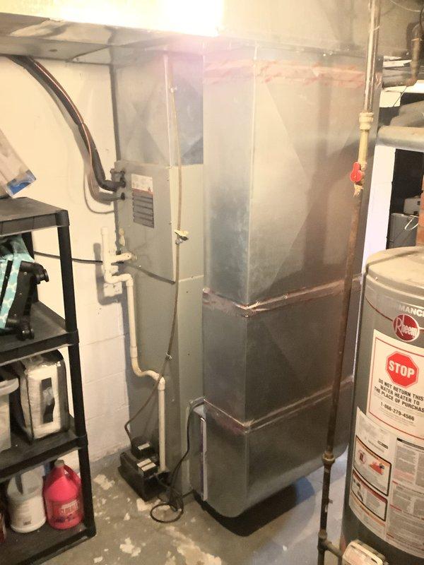 # HVAC Install - Complete System

Successfully completed installation of an 80% efficiency gas furnace system in basement utility area. Installed new furnace unit with proper ventilation ductwork, including horizontal and vertical duct runs secured to ceiling joists. Connected all electrical wiring and controls, ensuring proper power supply to unit with visible indicator lights functioning correctly. Coordinated installation alongside existing water heater to optimize space utilization in mechanical room. All copper refrigerant lines, PVC condensate drainage, and flexible ductwork properly routed and secured to manufacturer specifications. System tested and verified operational upon completion.