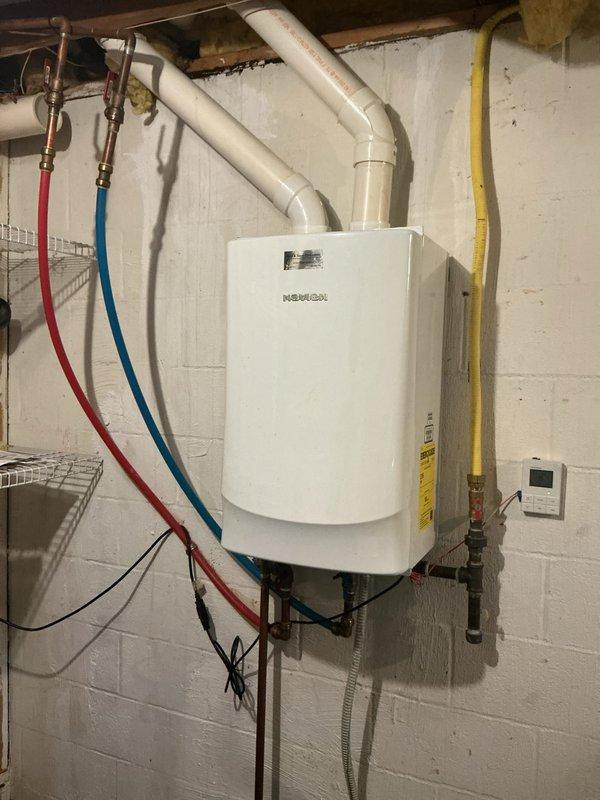 Responded to service call for tankless water heater providing hot water for only 1-2 minutes before running cold. Upon arrival, inspected wall-mounted Navien unit installed in basement utility area. Performed diagnostic testing of unit operation, checking gas supply, water flow rates, and ignition sequence. Examined temperature settings on digital control panel and verified proper venting through PVC exhaust system. Inspected copper water supply lines with isolation valves and yellow gas line connections for any restrictions or issues. Tested unit through multiple heating cycles to replicate reported symptom. Determined heat exchanger scaling or flow sensor malfunction as likely cause of premature shutdown. Flushed heat exchanger to remove mineral buildup and cleaned flow sensor. Adjusted temperature settings and verified proper operation through extended test cycles. Unit now maintaining consistent hot water temperature without premature cold water breakthrough. Documented photos of i