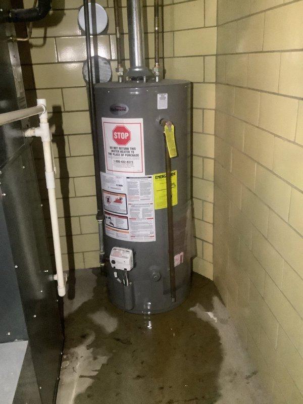 Responded to service call for leaking Richmond 40-gallon natural gas water heater, Model #6G40S-34F3, over 10 years old. Upon arrival, found significant standing water pooling around base of unit in utility room, confirming active leak from tank. Inspected water heater and determined tank failure due to age and internal corrosion, with leak originating from lower tank section. Recommended full unit replacement as tank leaks are not repairable. Documented existing installation configuration including copper supply lines, gas connections, and venting system for replacement specifications.
