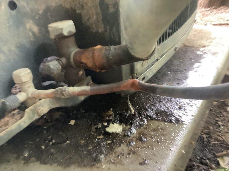 Responded to no cooling complaint on multiple 10-year-old air conditioning units. Upon inspection, discovered significant water accumulation inside HVAC cabinet and extensive corrosion on copper refrigerant lines and plumbing components. Standing water on unit floor indicated drainage system failure, with heavy staining on metal panels suggesting chronic moisture intrusion and possible secondary drain line blockage. Evaporator coil area showed debris accumulation and oxidation damage to copper piping connections. Documented severe corrosion throughout system components including rust on fittings and greenish patina on exposed copper. Water damage and deteriorated condition of refrigerant lines indicated system requires immediate attention to restore cooling functionality and prevent further damage to equipment.