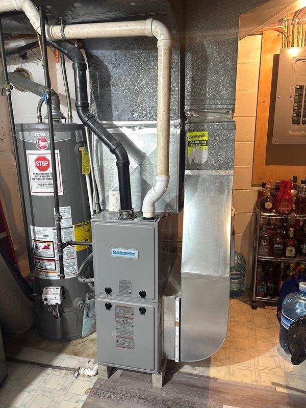 Completed installation of new air conditioning condenser unit and evaporator coil system as second phase of HVAC upgrade. Outdoor condenser unit was positioned on concrete pad with proper clearances from fence and siding, connected via copper refrigerant lines to indoor evaporator coil mounted above existing furnace in basement utility room. System was evacuated, charged to manufacturer specifications, tested for proper operation, and all electrical and refrigerant connections were verified for safe and efficient performance.