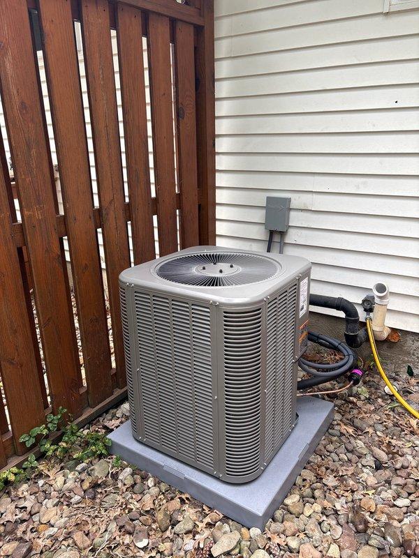 Completed installation of new air conditioning condenser unit and evaporator coil system as second phase of HVAC upgrade. Outdoor condenser unit was positioned on concrete pad with proper clearances from fence and siding, connected via copper refrigerant lines to indoor evaporator coil mounted above existing furnace in basement utility room. System was evacuated, charged to manufacturer specifications, tested for proper operation, and all electrical and refrigerant connections were verified for safe and efficient performance.