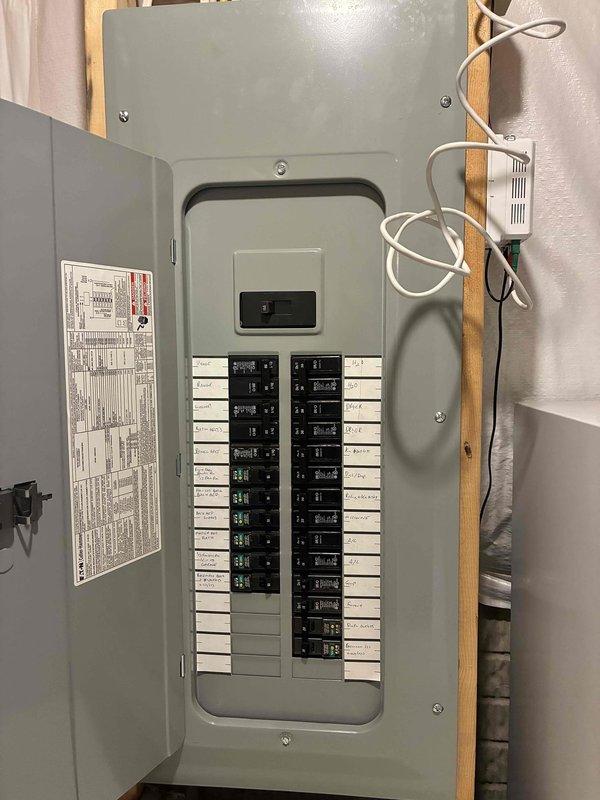Responded to service call for kitchen circuit issue affecting microwave and refrigerator in 16-year-old residence. Upon arrival, inspected main electrical panel located in basement utility area. Panel showed proper cable organization with bundled conductors entering through wooden framework at top. Tested and inspected dual-column breaker arrangement including main disconnect switch and individual branch circuit breakers. Identified tripped breaker serving kitchen appliance circuit. Reset affected breaker and verified proper operation of both microwave and refrigerator. Confirmed all connections were secure, panel components showed no signs of overheating or damage, and breaker labels were legible. Tested voltage at panel and verified proper function of reset circuit under load. All electrical components functioning normally upon completion. Documented panel condition with photos showing organized wire management and maintained breaker configuration.