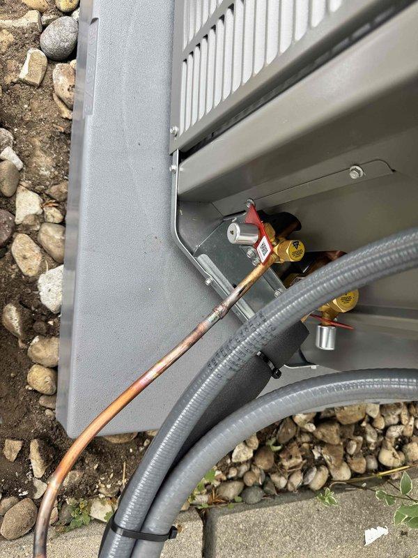 Completed full HVAC system installation including outdoor 90% AFUE gas furnace condensing unit positioned on concrete pad with proper gravel base for drainage and stability. Installed indoor air handler with complete refrigerant line set featuring insulated copper tubing, brass service valves, and proper electrical connections including capacitor wiring. Routed PVC condensate drainage lines and flexible ductwork to ensure efficient operation and code compliance.