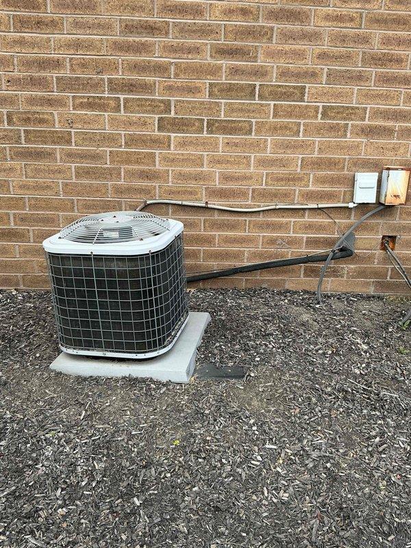 Conducted on-site HVAC system assessment for replacement estimate. Evaluated existing Comfortmaker furnace installation in basement utility area, documenting current equipment configuration including refrigerant line routing, electrical connections, and clearance specifications. Inspected outdoor condensing unit positioned on gravel pad against exterior brick wall, noting electrical disconnect box, conduit runs, and equipment placement. Photographed both indoor and outdoor components to provide comprehensive documentation for replacement system proposal.