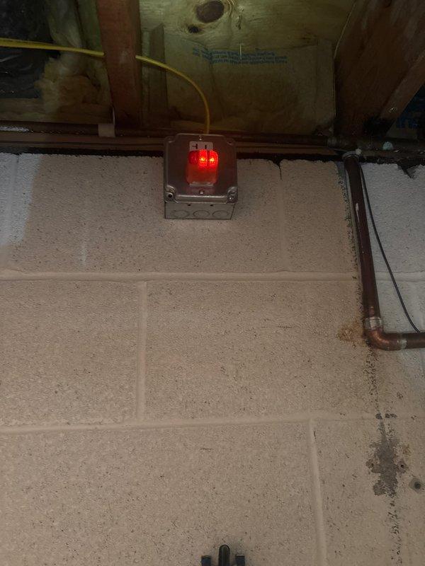Completed installation of basic plumbing circuit protection system in basement utility area. Installed water sensor device with LED indicator on copper supply line near water heater, mounted electrical monitoring equipment to floor joists in crawl space with proper wiring routing through insulation, and ran new electrical circuits along concrete block wall to support plumbing safety monitoring system.