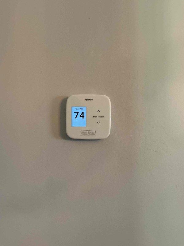 Responded to service call for malfunctioning thermostat. Upon arrival, inspected Aprilaire digital thermostat and associated low-voltage wiring connections at air handler. Found loose wire connections at junction point causing intermittent communication between thermostat and HVAC system. Secured all low-voltage wiring connections using proper wire nuts, verified proper voltage at thermostat terminals, and confirmed thermostat display and system response functioning correctly. System tested and operational.