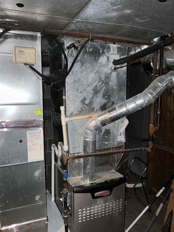 Conducted comprehensive assessment of existing HVAC system for equipment replacement estimate. Evaluated current installation consisting of aging air handler, Lennox furnace, and associated ductwork in basement mechanical room. Documented system configuration including refrigerant lines, condensate drainage, electrical connections, and duct transitions. Noted significant frost accumulation on evaporator coil indicating active cooling operation. Photographed equipment layout, clearances, and existing infrastructure to develop accurate replacement specifications and scope of work for customer consideration.