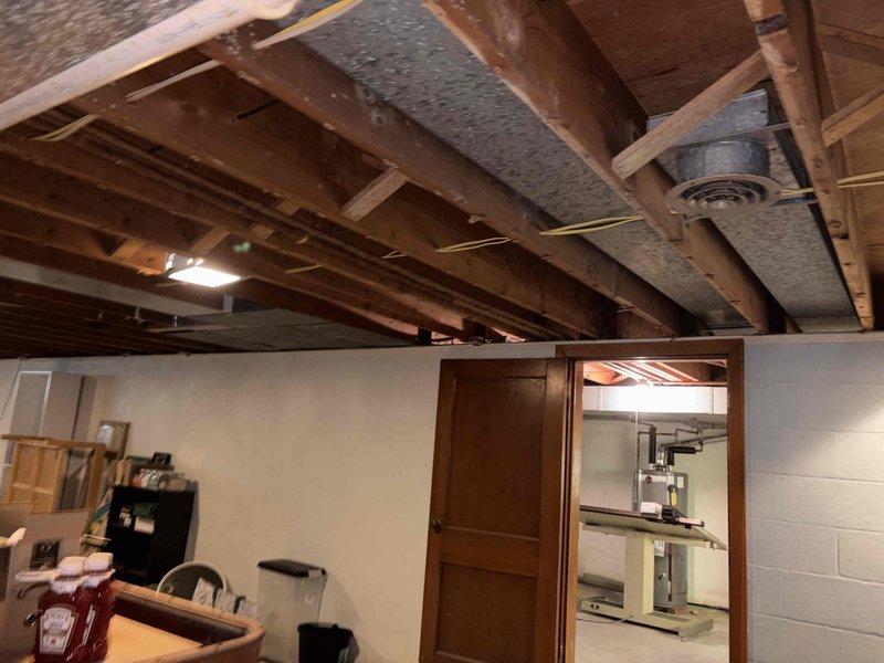 Completed estimate for replacement of 27-year-old HVAC system including new furnace and air conditioner installation. Scope includes new trunk line ductwork with reuse of existing branch takeoff vents where feasible, and installation of high wall return in master bedroom. Customer requested evaluation of existing ductwork condition in basement area with exposed joists and duct board insulation.