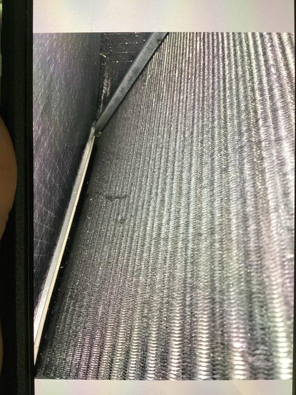 Responded to service call for 8-year-old air conditioning system not adequately cooling residence. Performed system diagnostics including visual inspection of evaporator coil and temperature measurements. Evaporator coil fins found in clean condition with proper airflow. Recorded ambient temperature reading of 74.6°F at air handler location to establish baseline operating conditions for further system evaluation.