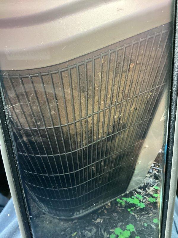 # HVAC Service Report

Responded to water leak complaint on 10-year-old Carrier central air conditioning system. Upon inspection, discovered severely clogged evaporator coil with extensive dirt, dust, and debris accumulation causing restricted airflow and condensate overflow. Evaporator coil displayed heavy discoloration from tan to dark green/black, with organic debris collected at base of unit. Back panel exhibited significant rust and corrosion from prolonged moisture exposure. Performed thorough coil cleaning, removed debris from drain pan, cleared condensate line blockage, and verified proper drainage. System tested and returned to normal operation with no further leakage detected.