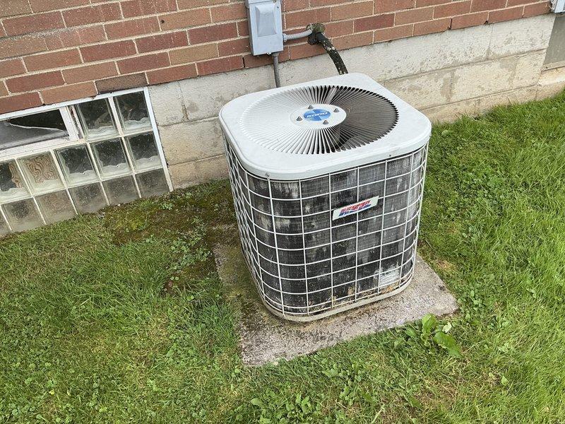 Performed comprehensive site evaluation of existing outdoor air conditioning system experiencing no cooling condition. Assessed cylindrical condenser unit with wire cage protection and electrical disconnect, documenting equipment condition, installation configuration, and accessibility for potential replacement. Provided estimate options for new system installation to restore cooling capacity.
