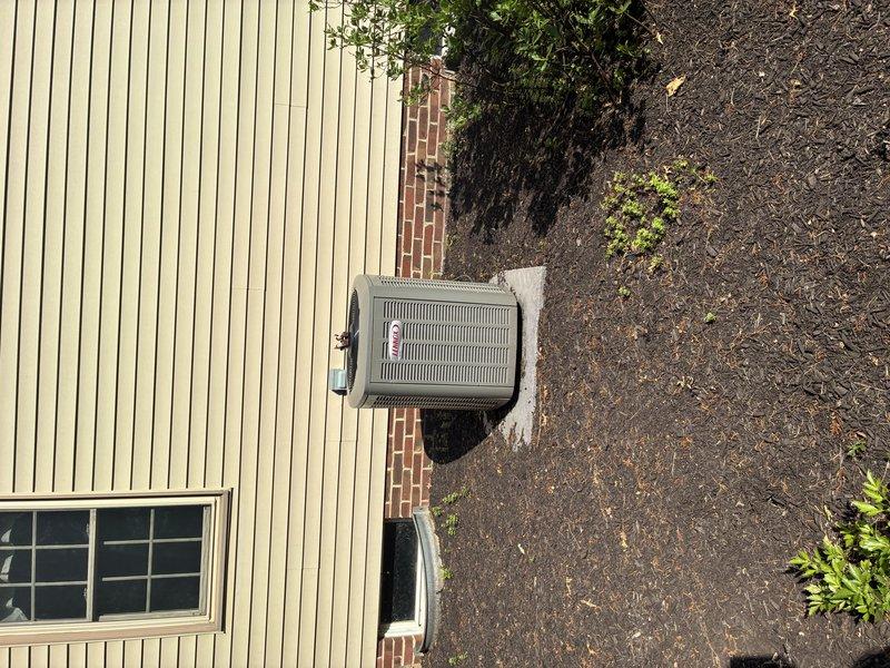 Completed MVP Cooling Visit recurring maintenance service on residential outdoor air conditioning condenser unit. Performed standard system inspection, documented equipment condition with interior and exterior photographs showing electrical components including capacitor and wiring connections in proper working order, and verified unit operational status on concrete pad adjacent to building.