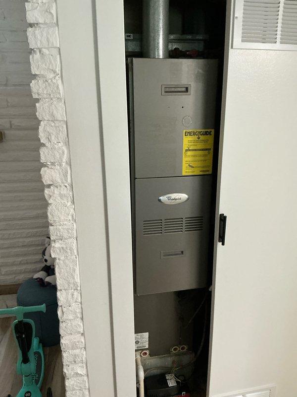Completed comprehensive HVAC system replacement estimate for residential property referred by existing customers. Assessed existing Whirlpool furnace system installed in interior utility closet and outdoor air conditioning condenser unit mounted on concrete pad adjacent to vinyl-sided exterior wall. Documented current system configuration including vertical furnace installation with overhead ductwork, copper refrigerant line routing, and outdoor condenser with disconnect box and refrigerant lines secured to building exterior.