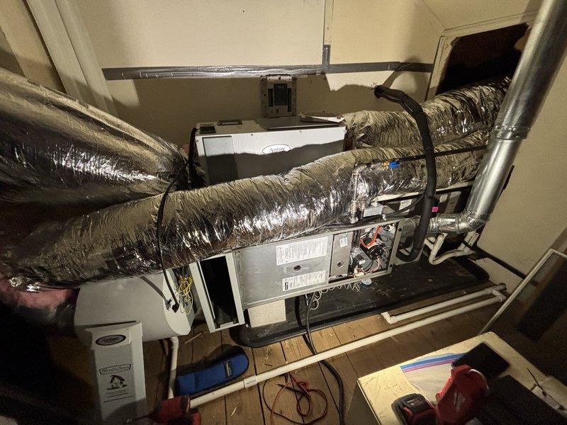 Completed comprehensive AC tune-up service on attic-mounted air handler unit during scheduled morning appointment. Performed standard maintenance inspection of all system components, including internal mechanical parts, electrical connections, and ductwork integrity. Inspected humidifier assembly and evaporator pad, noting mineral deposit buildup and discoloration indicating normal wear from extended use; system remains operational with all components functioning within acceptable parameters.