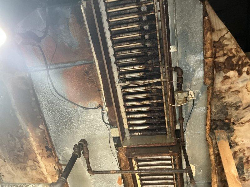 Conducted comprehensive estimate for ground-level HVAC unit replacement with evaluation of alternative rooftop installation option. Documented existing basement-mounted system showing aged heat exchanger coils, deteriorated ductwork assembly, and surrounding infrastructure with significant moisture exposure and structural wear. Assessed crawl space conditions revealing water-damaged floor joists, mold presence, and compromised insulation, which factors into replacement recommendations and installation planning.