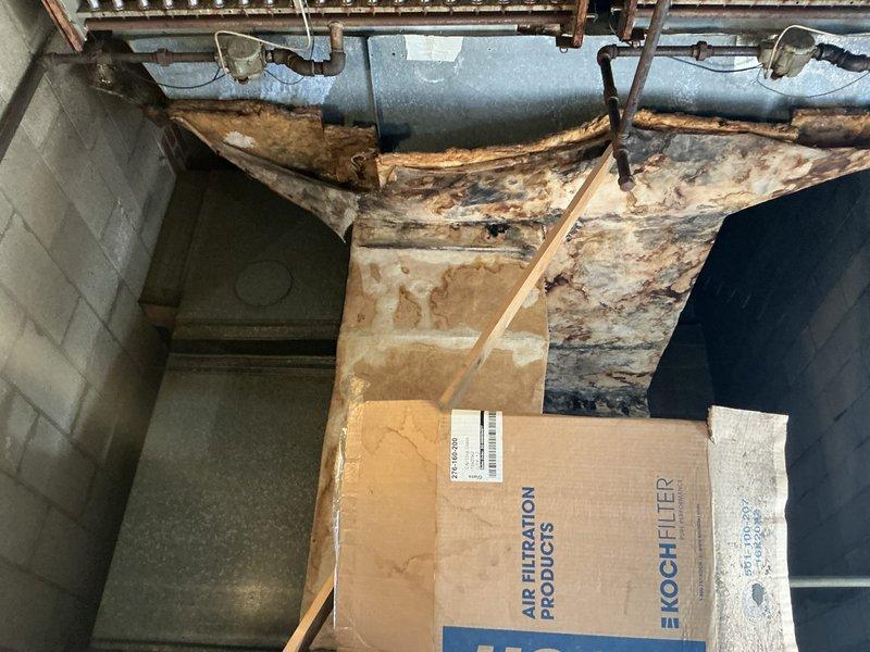 Conducted comprehensive estimate for ground-level HVAC unit replacement with evaluation of alternative rooftop installation option. Documented existing basement-mounted system showing aged heat exchanger coils, deteriorated ductwork assembly, and surrounding infrastructure with significant moisture exposure and structural wear. Assessed crawl space conditions revealing water-damaged floor joists, mold presence, and compromised insulation, which factors into replacement recommendations and installation planning.