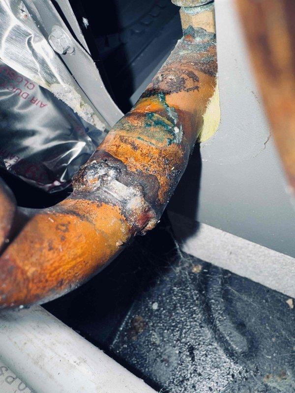 # HVAC Service Report

Responded to no cooling complaint on residential air conditioning system. Upon inspection, discovered severe fire damage to refrigerant line connections with extensive charring and heat damage to copper tubing and surrounding components. Additionally identified advanced corrosion throughout refrigerant piping with multi-layer oxidation, mineral deposits, and structural deterioration. System deemed unsafe for operation due to fire damage and compromised refrigerant lines requiring complete line set replacement and thorough inspection of electrical components to determine fire origin before restoration.