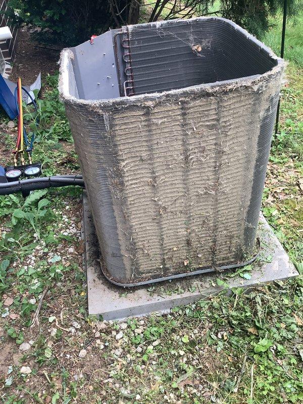 Responded to no-cooling complaint on 10-year-old residential air conditioning system. Upon arrival, found outdoor condensing unit heavily soiled with dirt, dust, and debris accumulation on exterior surfaces and coil areas. Performed diagnostic testing with manifold gauges to assess system pressures and operational status. Inspected indoor air handler and discovered severely clogged cylindrical pleated air filter with significant dust and particulate buildup restricting airflow. Replaced dirty filter with new unit to restore proper system airflow and efficiency. Cleaned condensing unit exterior and coil surfaces to improve heat transfer capability. System restored to normal cooling operation.