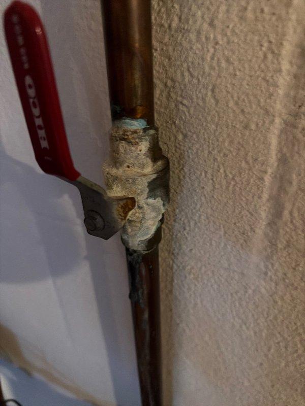 Responded to service call for bathroom sink experiencing air trapped in supply line. Upon inspection, discovered significant mineral buildup and corrosion on vertical supply line shut-off valve with HUOT ball valve assembly showing heavy calcium deposits at threaded connection points. Assessed copper piping for pinhole leaks and corrosion damage that could be causing air infiltration into the water supply system. Provided quote for replacement of corroded shut-off valve on vertical supply line. Additionally inspected AprilAire humidifier system for reported leak condition while on-site.