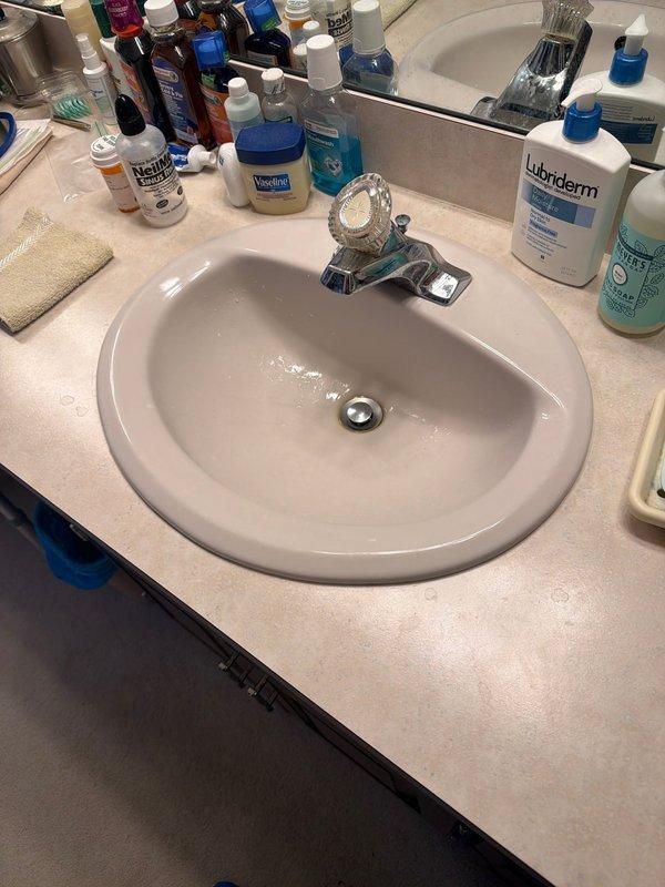 Responded to service call for bathroom sink experiencing air trapped in supply line. Upon inspection, discovered significant mineral buildup and corrosion on vertical supply line shut-off valve with HUOT ball valve assembly showing heavy calcium deposits at threaded connection points. Assessed copper piping for pinhole leaks and corrosion damage that could be causing air infiltration into the water supply system. Provided quote for replacement of corroded shut-off valve on vertical supply line. Additionally inspected AprilAire humidifier system for reported leak condition while on-site.