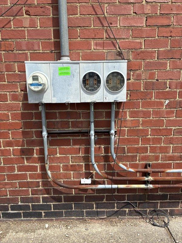 Completed electrical service upgrades to meet code requirements for re-energization. Installed two new ground rods for proper service grounding, with grounding electrode conductors routed along exterior building wall. Established bonding connections for water service line and bonded hot water, cold water, and gas piping systems per NEC requirements. Installed two new dedicated circuits for electric water heater installations—first circuit terminated near main panel location, second circuit extended across basement to exterior wall with exterior-rated disconnect and flexible conduit whip connection to water heater unit.