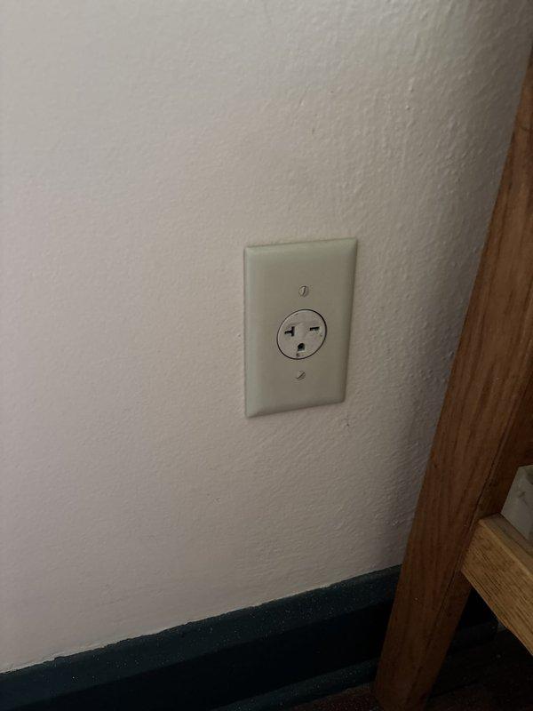 Installed a new 20-amp, 220-volt dryer receptacle in the bathroom, running dedicated circuit wiring from the main electrical panel across the room to the new outlet location. The three-prong dryer outlet was mounted on the wall with proper faceplate installation, ensuring code-compliant electrical service for the appliance.